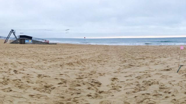 Panorama shot view of beach with Plastic Pathways - beach labyrinth on the sand for Arts by the Sea festival by artist Michelle Rumney