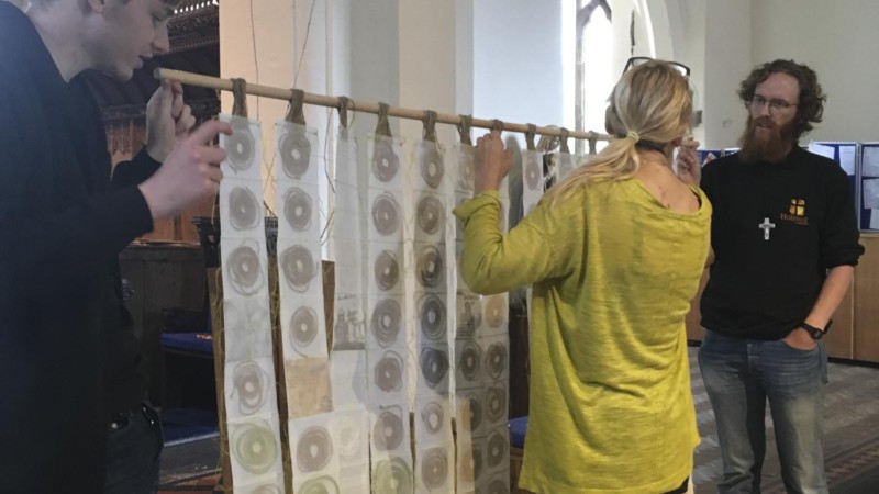 artwork being installed hanging from the bell tower of St Marys Priory Church Abergavenny in Wales - part of the St Thomas Way